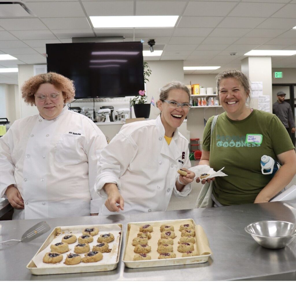 Student and teachers pose with cookies they prepared for an event.